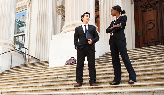 Two professionals talking on stairs of a building