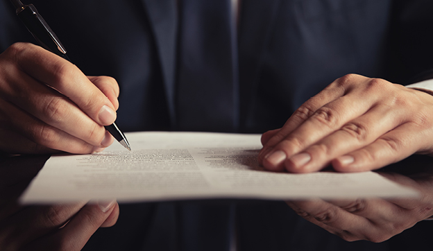 Close-up of hands writing on paper